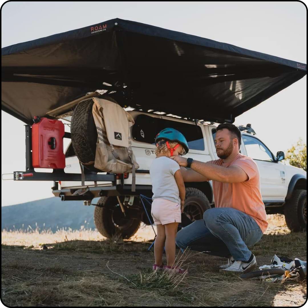 A lifestyle image of a dad and daughter using their awing while camping