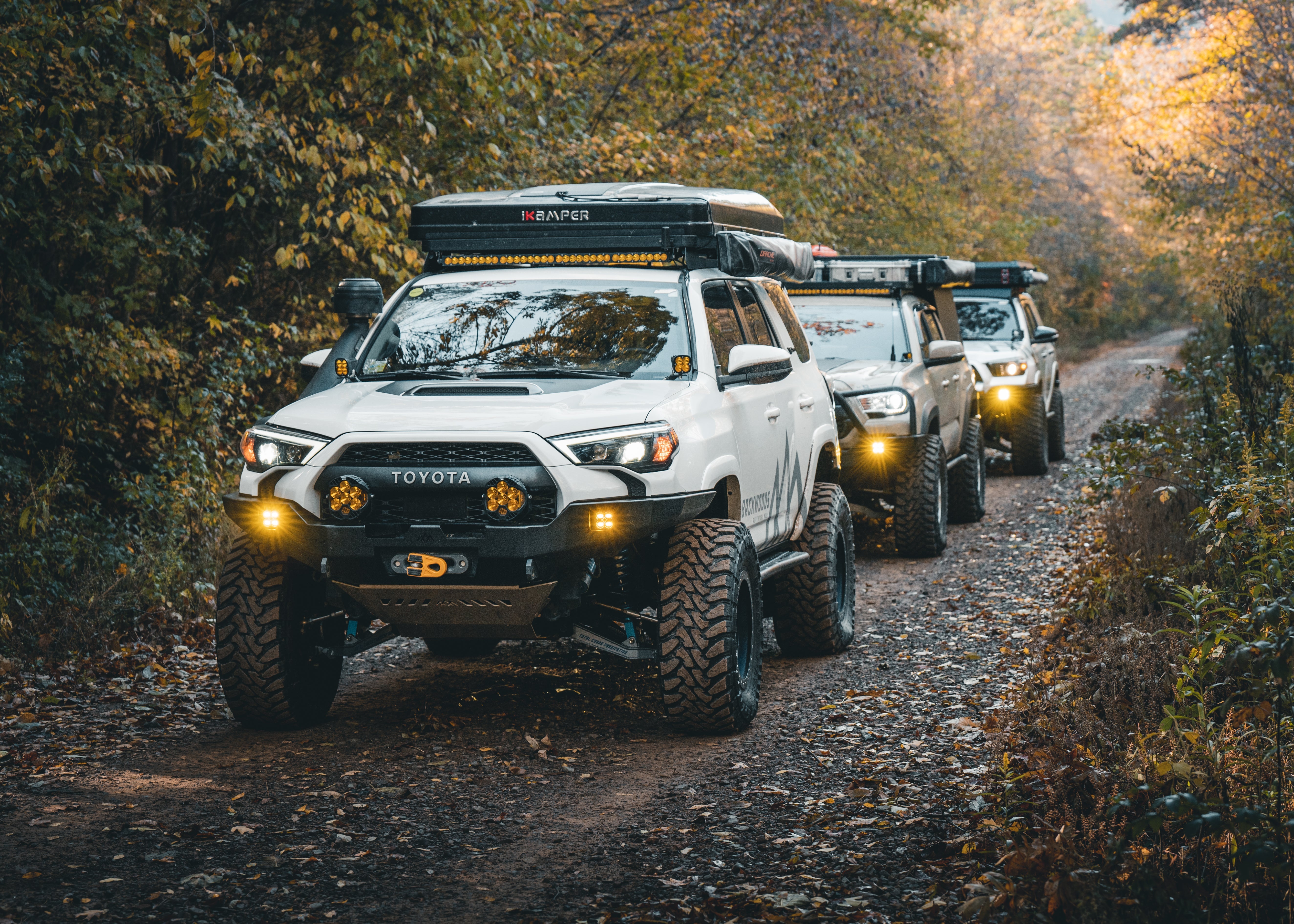 Built Toyotas lined up on an off road trail