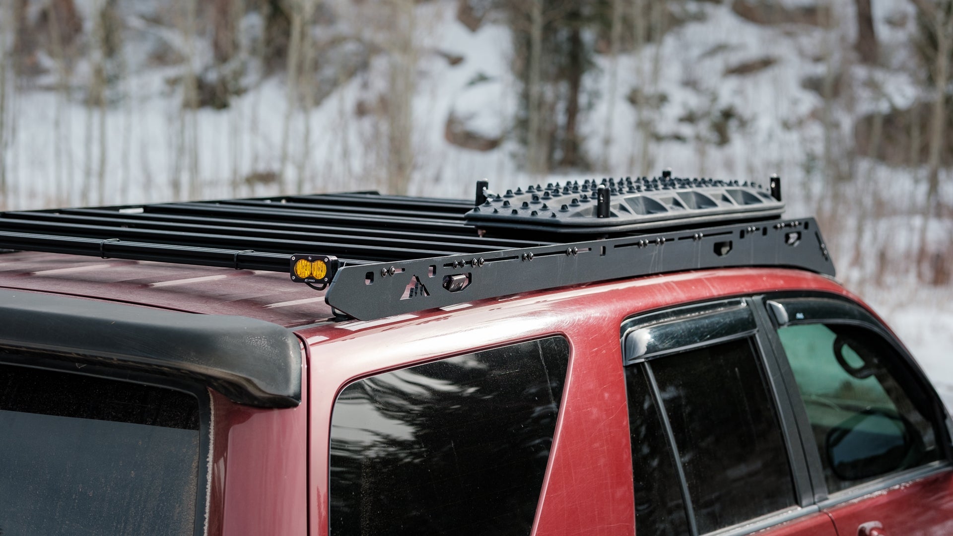 A red 4th gen 4Runner with a Sherpa Princeton roof rack with accessories on top